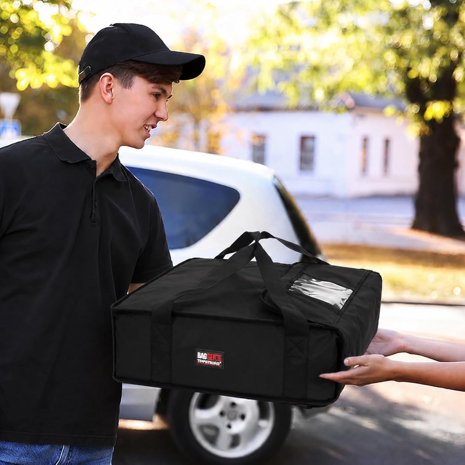 Delivery driver handing a Bag Genie insulated pizza delivery bag to a customer